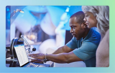 Bild på en kvinna och en man som pekar på en skärm och diskuterar