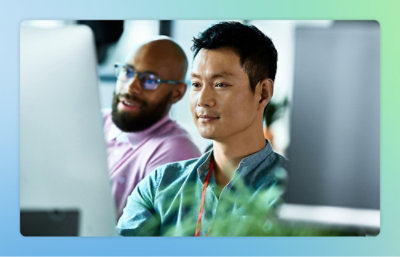 Två män tittar på skärmen och ler