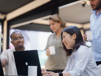  A group of people looking at a laptop.