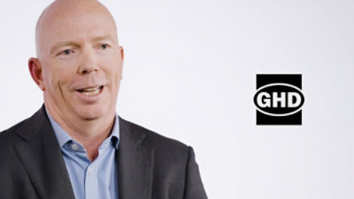 A man in a suit with the text GHD visible.