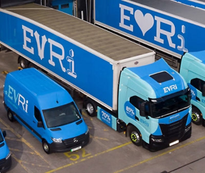 Blue EVRi delivery trucks and vans parked in a depot, with large EVRi branding on the sides.