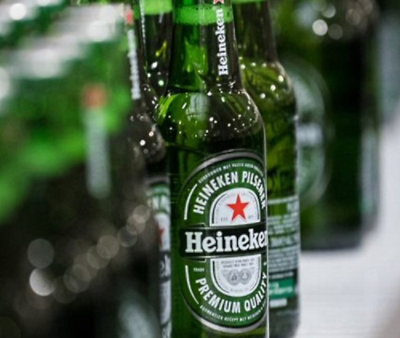 Close-up of green Heineken beer bottles with labels visible and condensation on the glass.