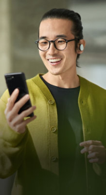 A man smiling is looking at the mobile.