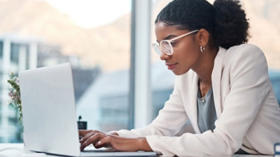 A woman is working on a laptop.