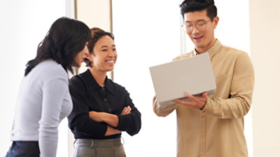 A group of people looking at the laptop.
