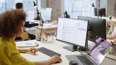 A woman is looking at the laptop.