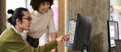 A woman with hair looking at a laptop at a table.