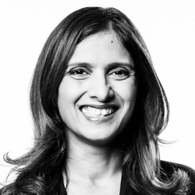 Portrait of a person smiling, facing forward, black and white.