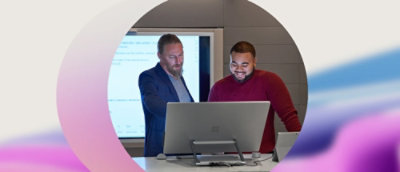 A group of men standing in front of a computer.