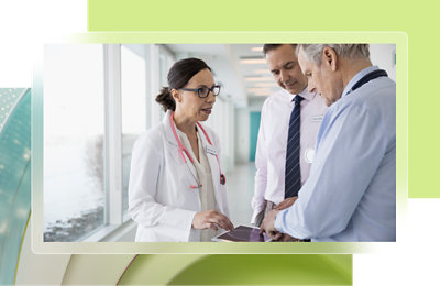 A woman in a white lab coat discussing with 2 men's using a tab.