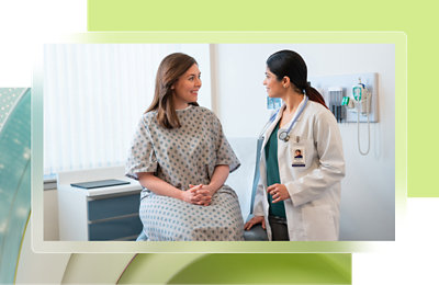 Une femme assise à un bureau et parlant à un patient.