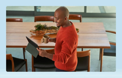 Une personne tenant une tablette et une tasse de café