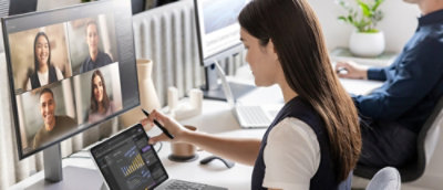 A woman sitting in office environment and looking at the screen