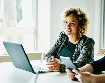 A women sitting at desk work on laptop