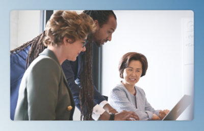 A group of people looking at a laptop.