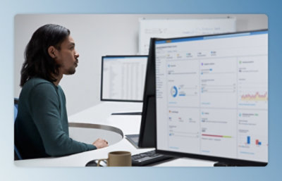 A person sitting at a desk looking at a computer screen with a graph displayed.