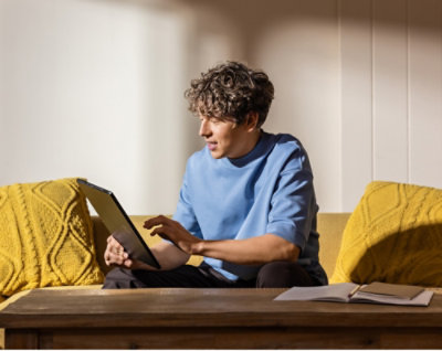 A person sitting on a couch using a laptop.