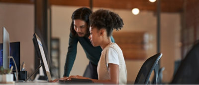 A man and woman looking at a computer.