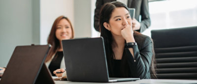 A woman sitting at a table with a laptop.