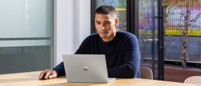 A man sitting at a table with a laptop.