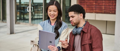 A man and a woman looking at a tablet.