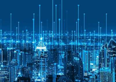 A city skyline with many illuminated buildings at night.