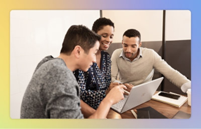A group of people looking at a laptop.
