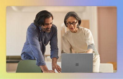 A man and woman looking at a laptop.