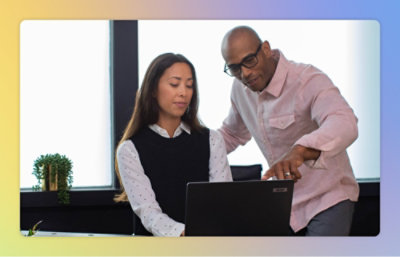 A man and woman looking at a laptop.