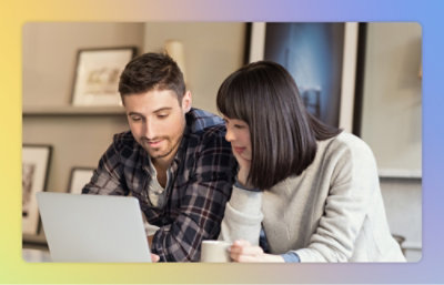 A man and woman looking at a laptop.