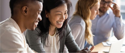 A group of people working together at a desk with a laptop.
