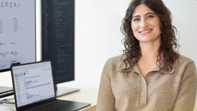 A woman sitting in an office environment and smilling