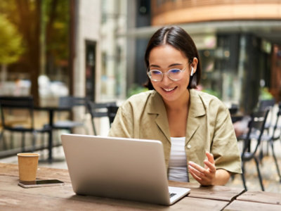 A women sitting at a table using a laptop.