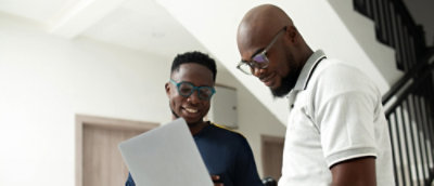Two man looking at laptop screen.