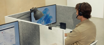 A person sitting at a desk wearing headphones.