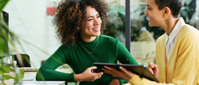 A person in a green shirt holding a tablet.