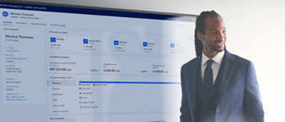 A man in a suit looks at a computer screen with a white background.