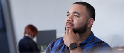A blurry image of a person's head wearing a watch.