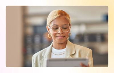 A person wearing glasses and a tan jacket.