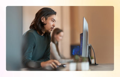 A man in a green shirt using a computer.