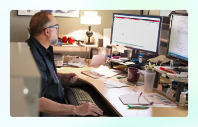 A man sitting at a desk using a computer.