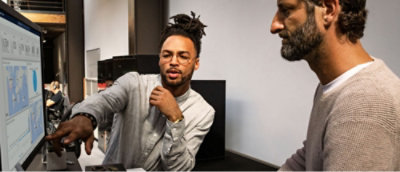 Two man looking at the screen and discussing