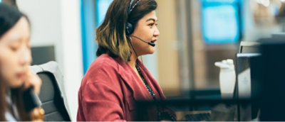 Woman wearing headphones looking at the screen