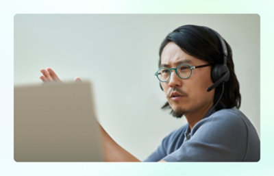 Man with headset explaining something on laptop