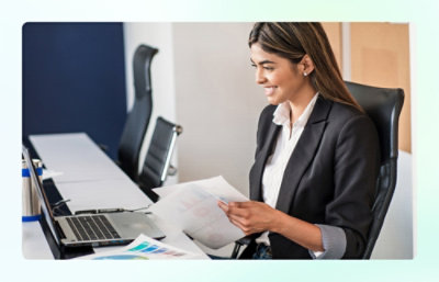 Woman reviewing documents on laptop