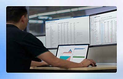 Man reviewing charts and graphs on 3 different monitors