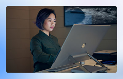 Person working at a large desktop computer in a modern office.