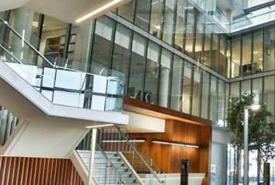 Modern office interior with glass walls and staircases.