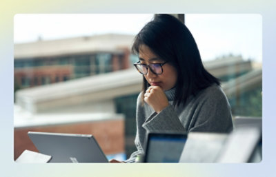 Person using a laptop near a large window in an office setting