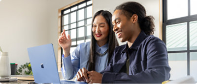 Un bărbat și o femeie se uită la un laptop.